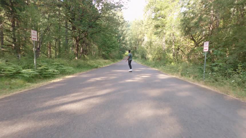 A man is skateboarding on the road