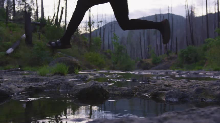 A person is jumping over water outdoors