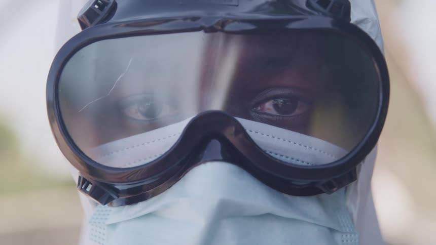 A black person wearing a head covering mask and goggles looking forward