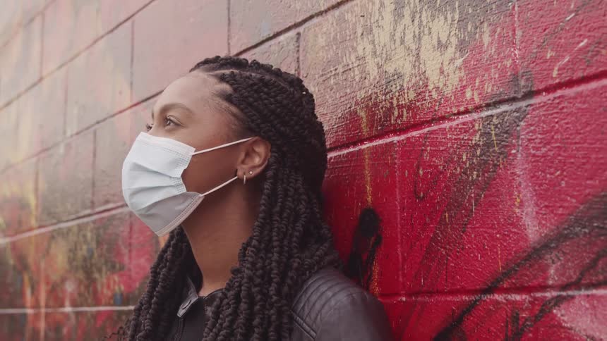 A portrait of a woman standing against a wall