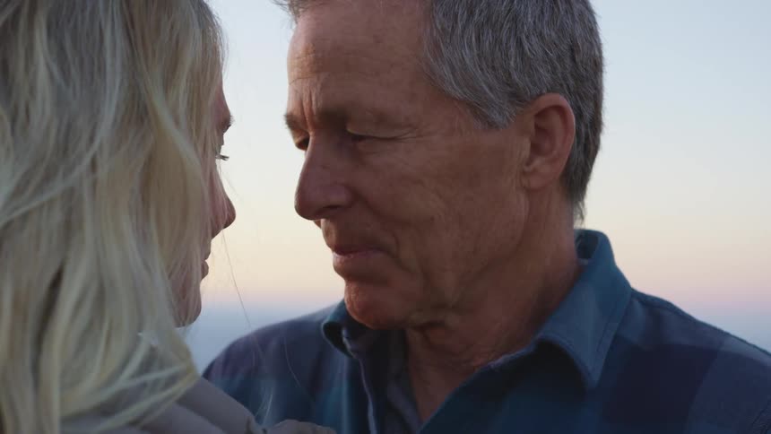 A man and woman are standing outdoors together