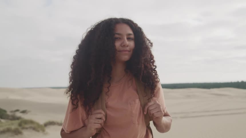 A woman is smiling on the beach