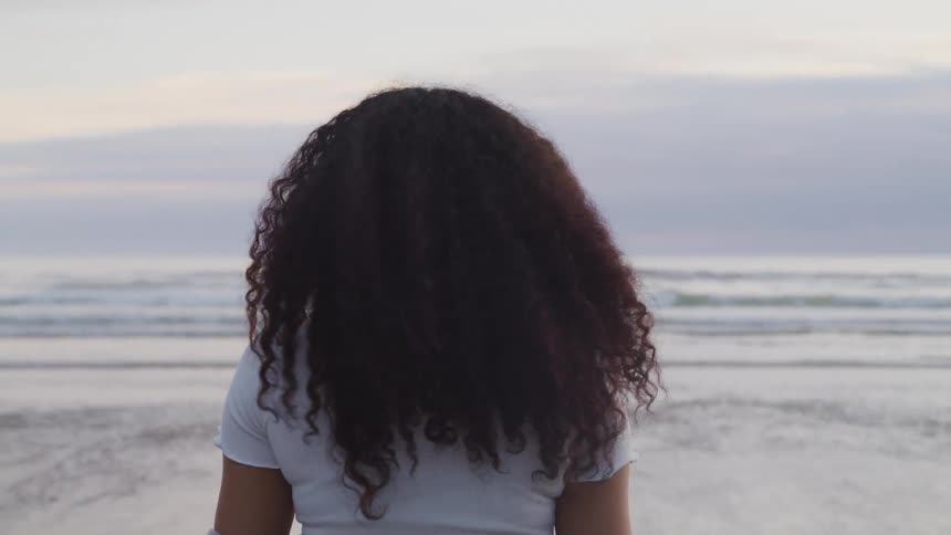 A woman is looking around the beach
