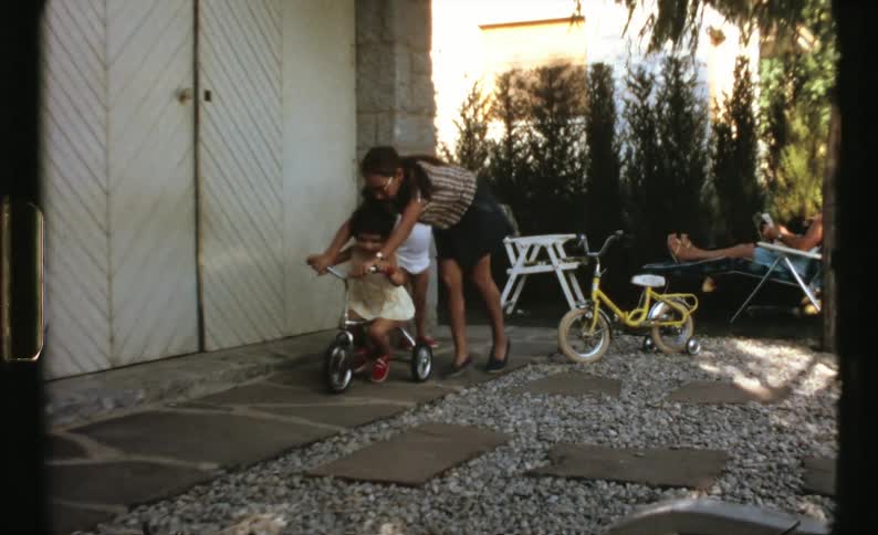 Kids are outdoors riding bikes in their backyard