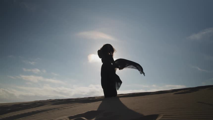 A woman is standing outdoors and wearing a dress