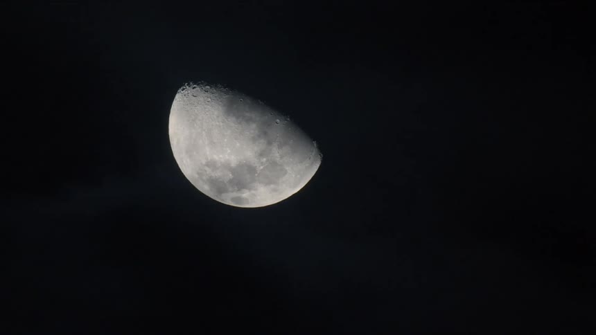 The moon in the sky with clouds moving in front of it