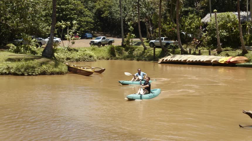 Two people row boats on the water