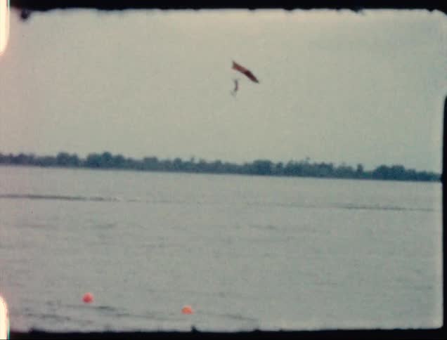 A person paragliding over a lake in the daytime