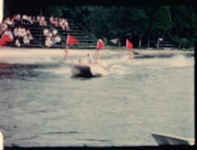 Water ski show attraction in a water park presented to a crowd caught on vintage film