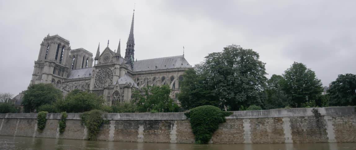 A large church near a river on an overcast day
