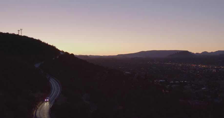 Car driving on a hill side above a city