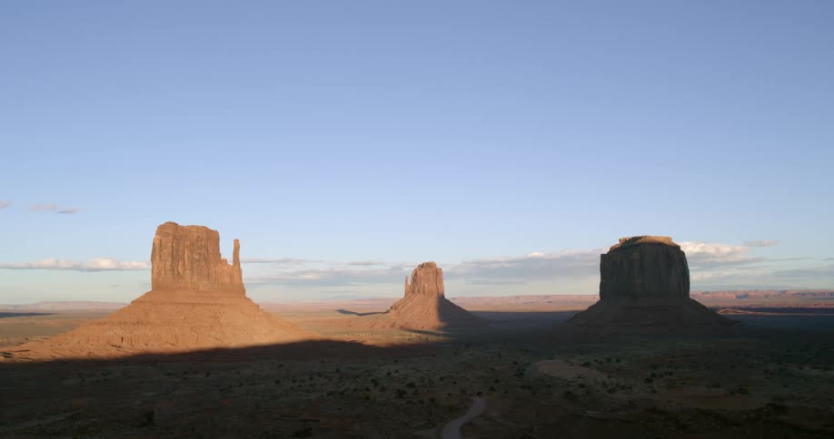 Shadow line across rock formations in the desert under a blue sky