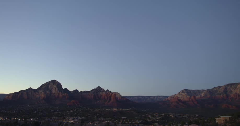 A small town in the desert with mountains and the sky in the background