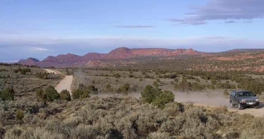 A vehicle driving on a dirt road in the desert