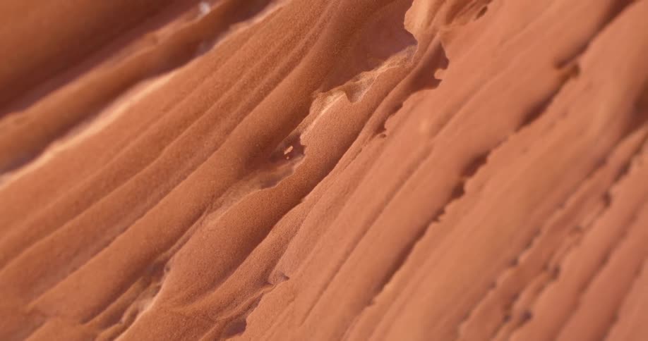A microscopic view of reddish surface reveals that it has a wave like surface with a number of notches and crevices