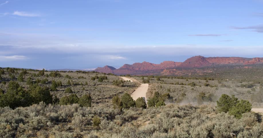 A car driving on a dirt road in the desert