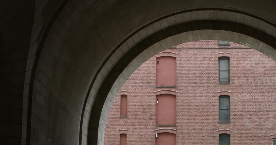 A red brick building seen through an arch