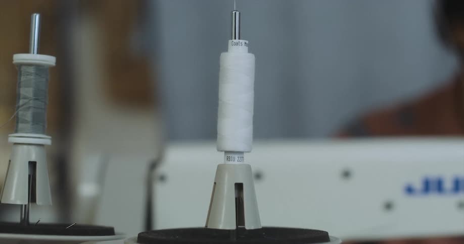 Thread flows from spool near sewing machine