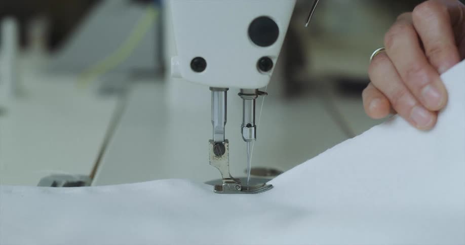 A woman sewing material with a sewing machine