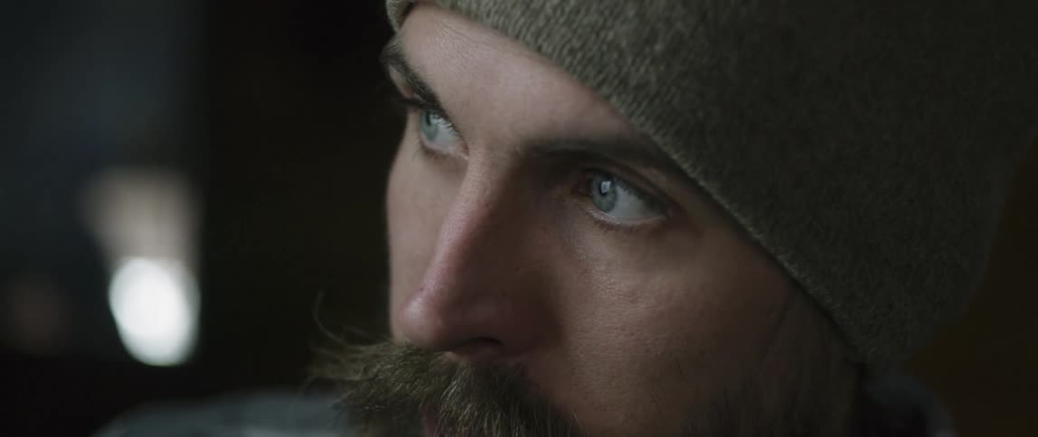 A mustached man is deep in thought