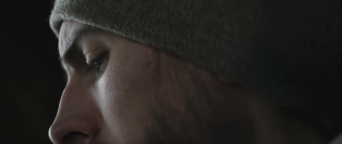 A man's eyes are cast downward