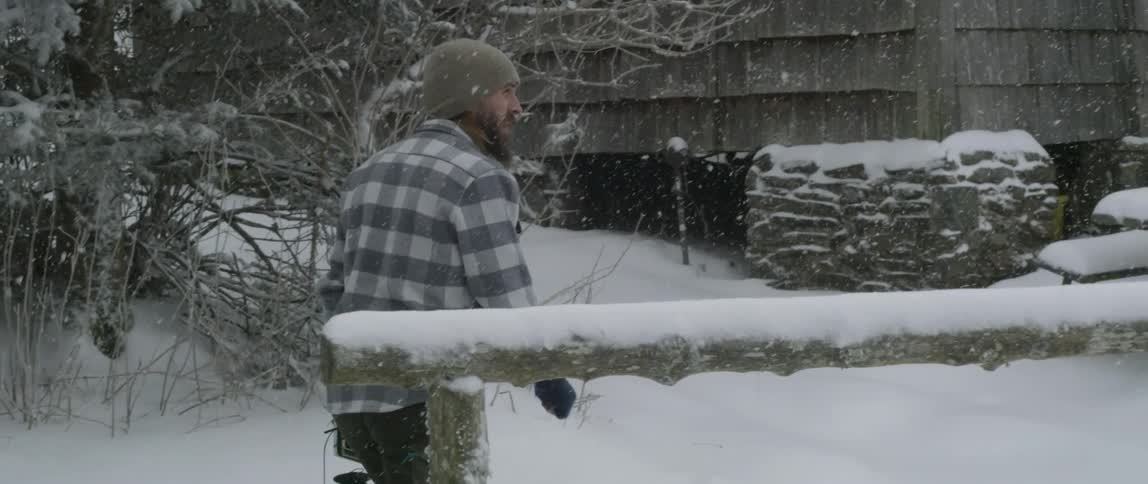 A man walks outside in the snow