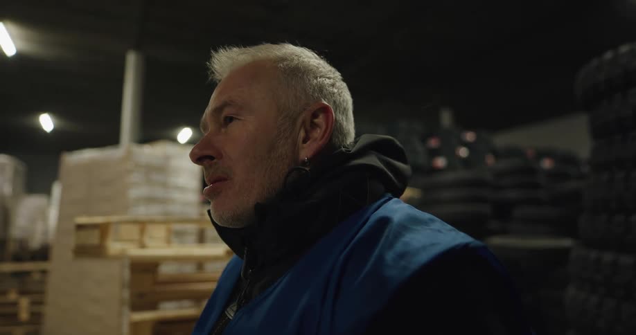 A man sitting in a warehouse sipping coffee