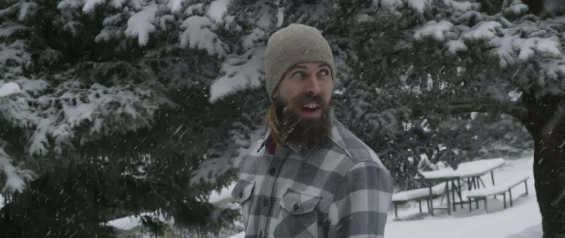 Man is standing outside in snow storm and smiling