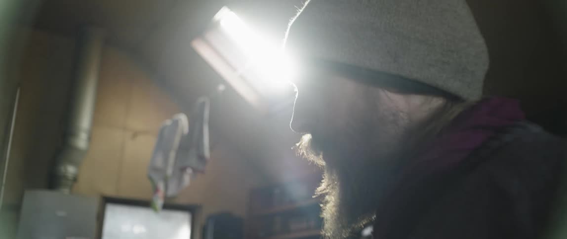 Man stands in a garage sipping out of a mug