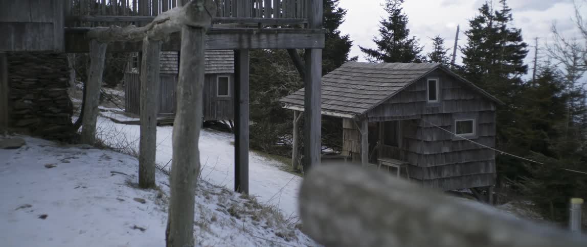 Man In Mountain Log Cabins During Winter
