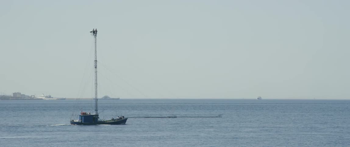 A boat moves across water on a clear day
