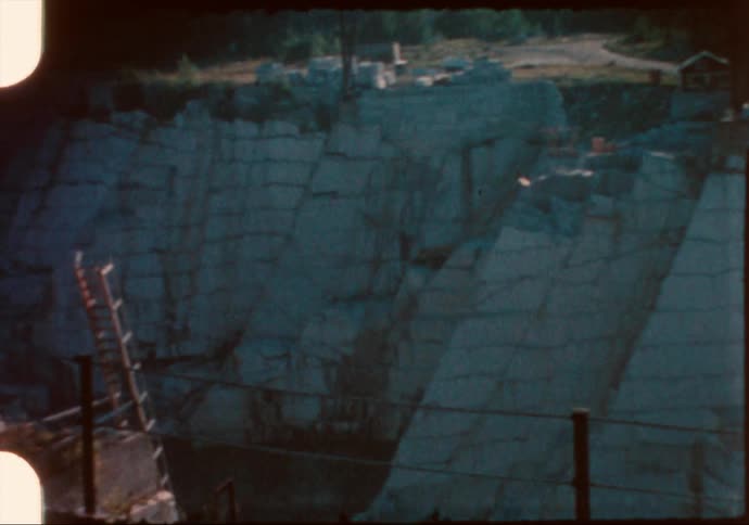 A low wire fence blocks access to a rock quarry under construction