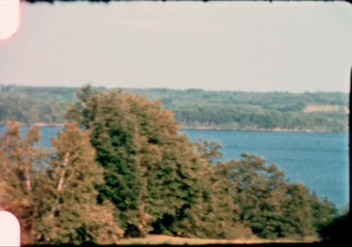 Vintage film footage of a lake in the middle of a forest