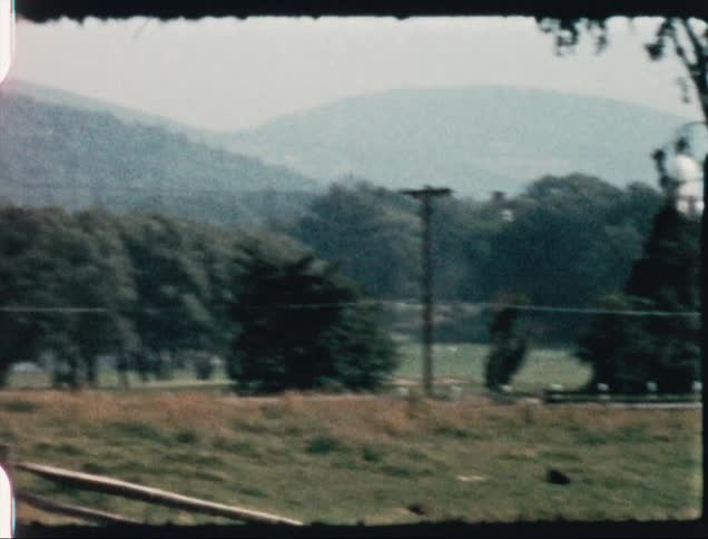 A view of farmland and a small hosue