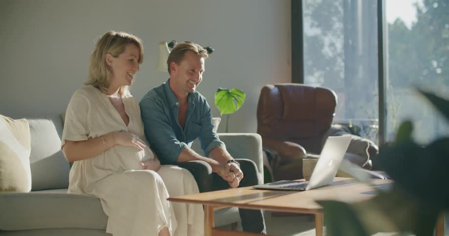 A man and woman talking to someone on a laptop