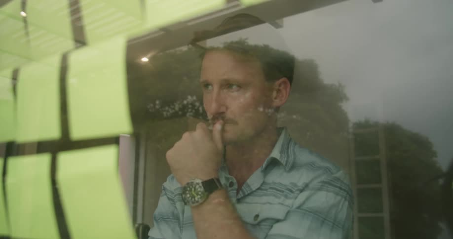 A man looking at notes on a window