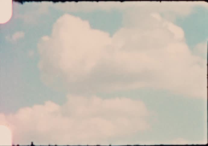 A vehicle driving by with the sky and clouds in the background