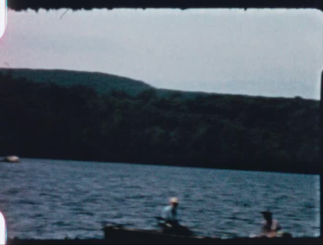 A lake with trees plants the sky and clouds in the background