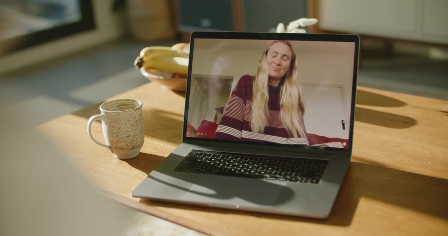 A woman talking on a laptop screen