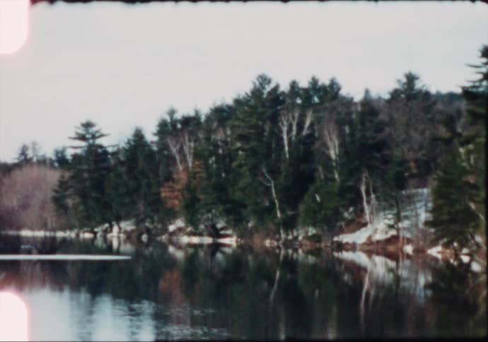 A lake in the middle of a snowy forest