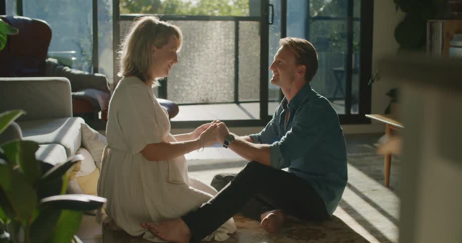 A man and woman holding hands and sitting