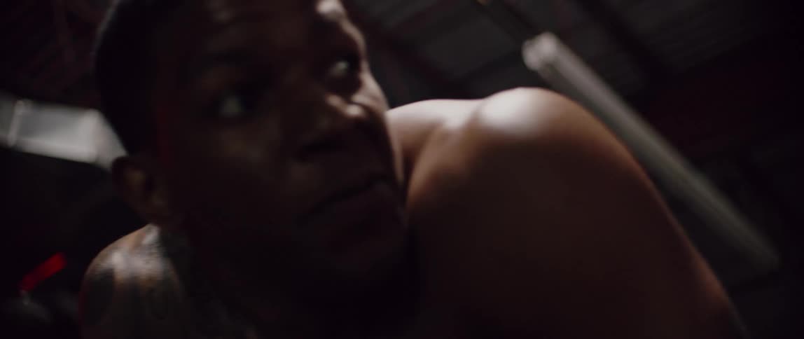 A shirtless man bends over as he catches his breath