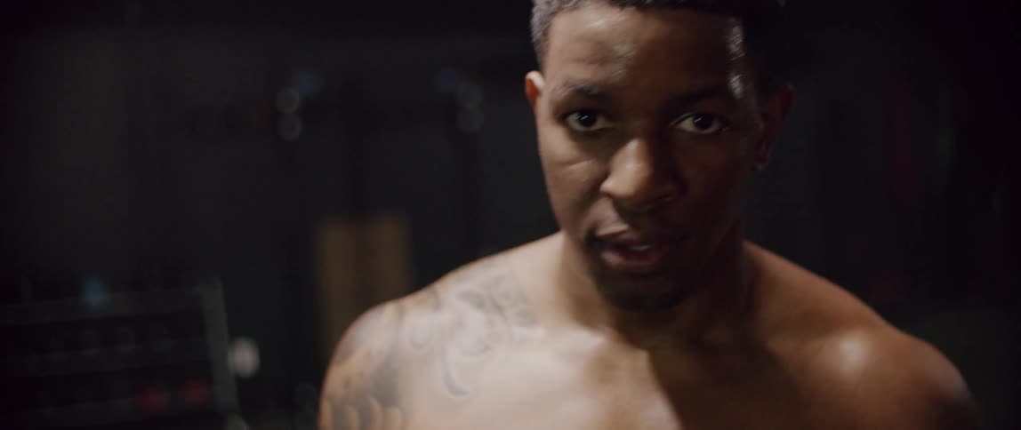 Shirtless man breathes heavily in a gym