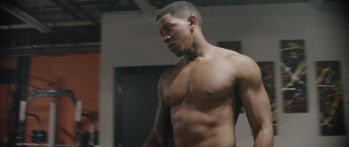 Man stretching in front of a mirror in a gym