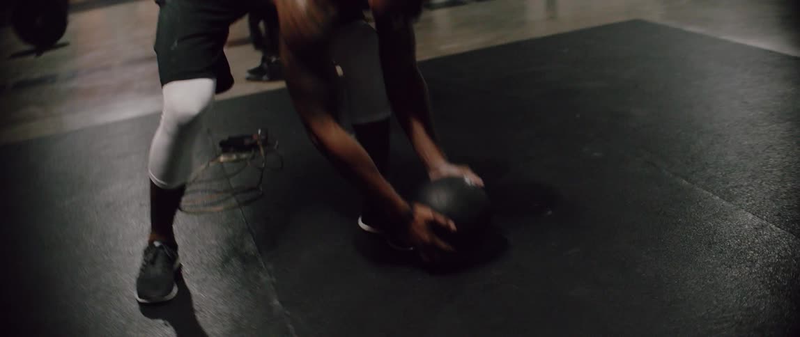 Person picks up a ball and slams it on a gym floor