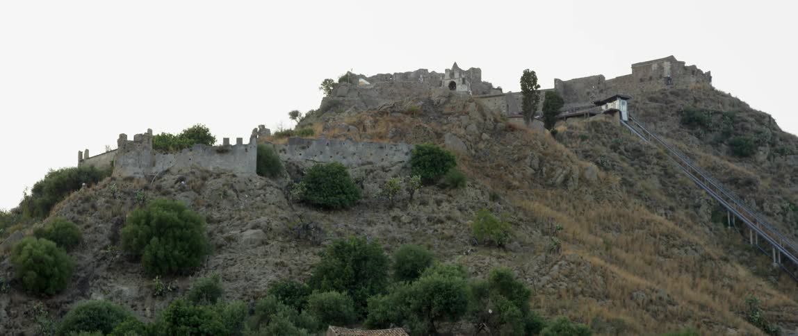 A wall on a rocky, shrubby cliff