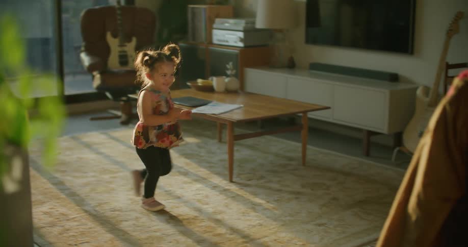 Father playfully runs with daughter in living room