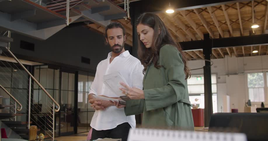 A man and woman look over paperwork and talk