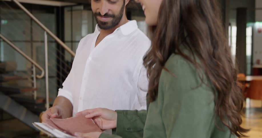 A man and woman look at notes and talk