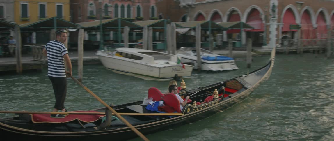 A man steers a boat through the water
